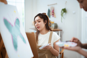 Two Asian women painting watercolor together in art studio at home © DG PhotoStock