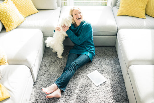 Playful woman with dog in living room