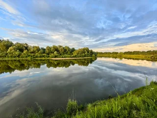A summer river landscape: sunset, wildflowers, and the sky. © Nadzeya Pakhomava