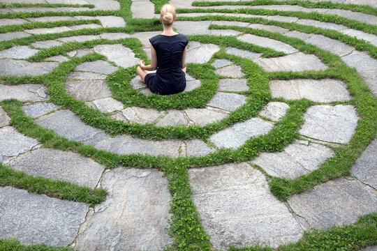 Italy, Alto Adige, Lana, woman sitting in natural open air maze meditating