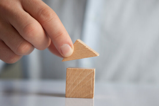 Man building up house with building blocks, close-up