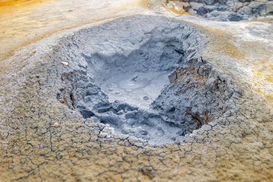 Grey mud bubbles in a parched crater at Hverir Geothermal Area