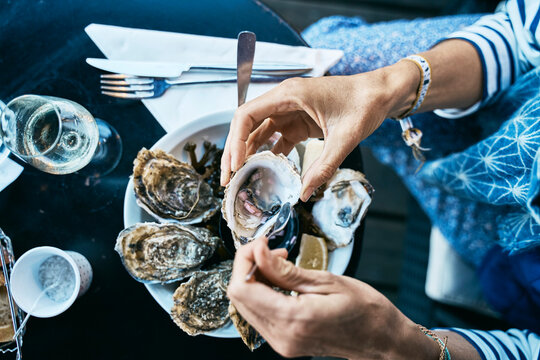 Woman having oysters at table
