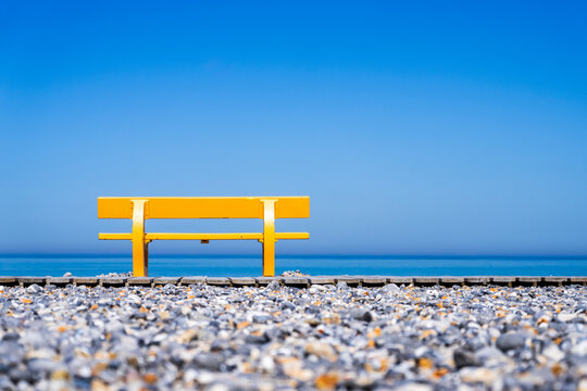 Empty yellow bench on a beach with sea view in Le Treport