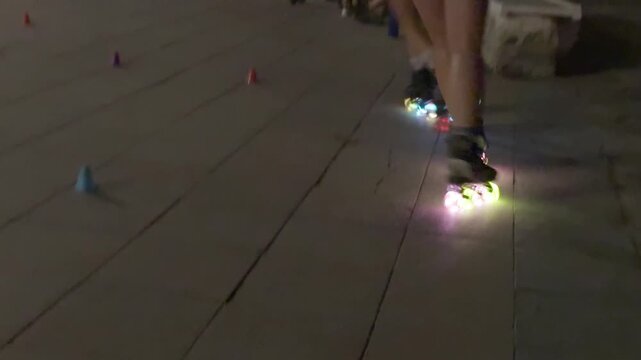 People inline skating with glowing led wheels at night