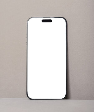 Blank smartphone mockup on beige background. Vertical mobile phone with white screen and minimal studio setup. Ideal for app design, advertising, and product presentation..