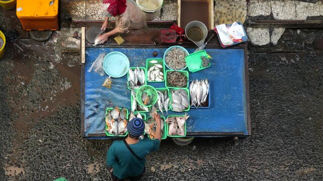 A bustling fish market comes alive during the early morning hours, where vendors and buyers engage in the daily trade of fresh seafood and fish. Operating from around midnight until 7am