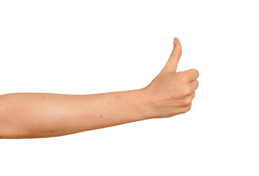 Extended arm showing a thumbs-up sign. Woman s forearm reaching sideways with an approving gesture.