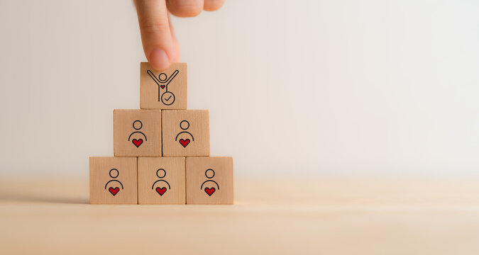 Employee Motivation or Brand Loyalty concept. Wooden blocks with employee blocks with heart symbols, representing motivation, brand loyalty, employee engagement, recognition and commitment.