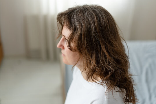 A woman considers how hormone balance directly affects her graying hair. The mature adult works to maintain healthy levels for better silver strands. Mother prioritizes endocrine health for aging.
