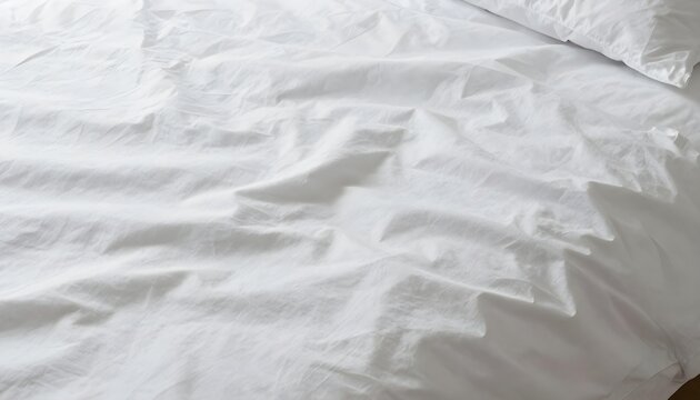 Close-up high-angle shot of a white crumpled bedsheet with soft lighting