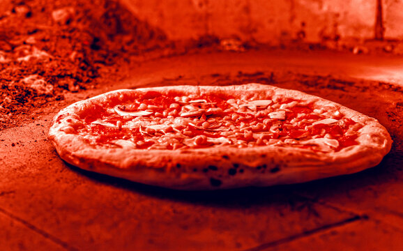 Dough in a oven with open fire. Pizza concept. Preparing traditional italian pizzas