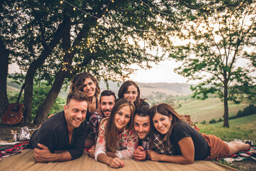 Obraz premium Group of friends spending time making a picnic and a barbeque