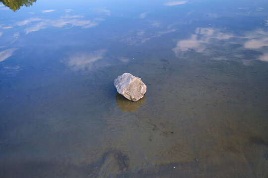 Rock reflected in still water