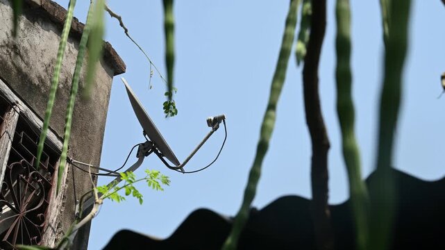 A DTH (Direct-to-Home) connection dish antenna is installed on a roof wall facing south of a house situated in a forest. United States has listed India&rsquo;s preference for the use of domestic satellites 