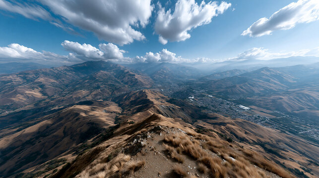 Mountain cityscape panoramic mountain town cloud valley ridge sky overlook from dry grass summit vast landscape vista