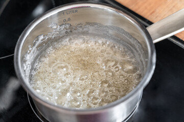Sugar melting in pot for caramel making with bubbles forming on surface, cooking and confectionery © molenira