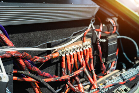Close-up view of car audio system with intricate wiring harness and power distribution block for custom sound installation and car tuning project
