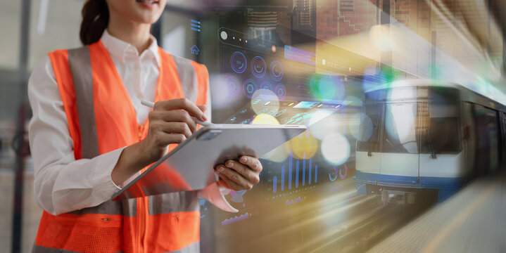 A female engineer or inspector wearing an orange safety vest and hard hat using a digital tablet with a stylus, featuring double-exposure data graphics and a modern train transit background.