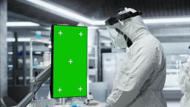 Doctor In Hazmat Suit Examining Patient With Green Screen