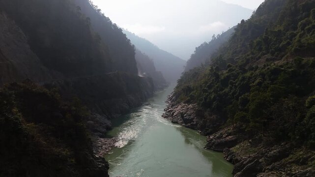 Drone following the green Trishuli river winding in a deep mountain gorge in Nepal