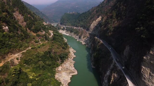 Drone shot of the winding Prithvi highway cutting a steep mountain valley in Nepal