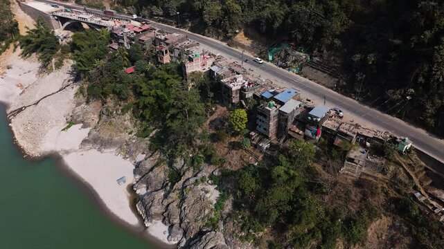 Aerial view rotating toward roadside houses along Prithvi highway in sunny Nepal