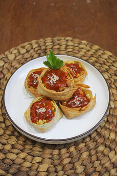 Crispy Fried Dumplings With Chili Sauce On Woven Mat