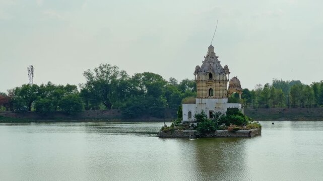 Static shot of the historic Shiva Temple standing on a small island in Rani Talab Lake at Rewa in Madhya Pradesh under calm daylight conditions