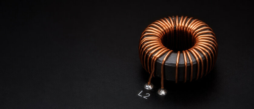 Copper Toroidal Inductor Mounted on Black Circuit Board