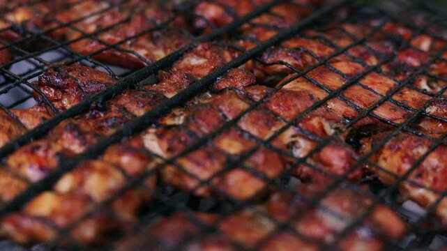 Close-up of delicious chicken wings grilling on a barbecue rack outdoors