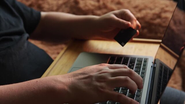 Person using laptop and credit card for online shopping at home