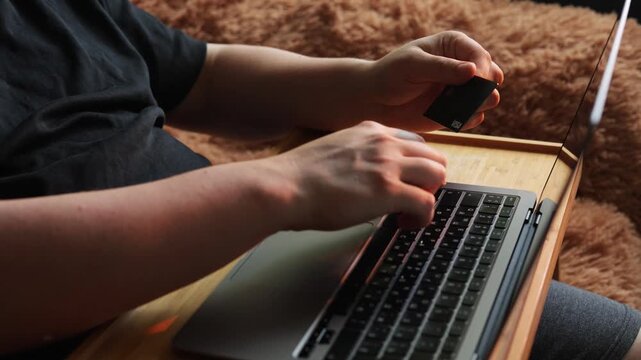 Person using laptop and credit card for online shopping or banking
