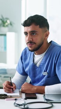 Clipboard, healthcare and talking with nurse man in hospital for appointment or consulting. Conversation, paperwork and writing with happy medical professional in clinic for feedback or review
