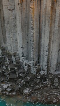 Vertical basalt columns rising above broken rock in Iceland