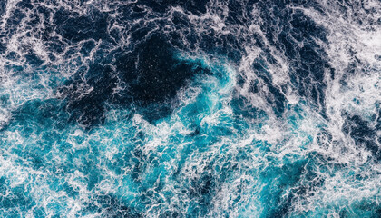 Fototapeta premium Ocean water churns with foamy waves and contrasting deep blue and turquoise tones. The image shows dynamic sea motion and texture suitable for backgrounds or design with copy space.