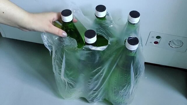 Multipack of bottled water stored at home, female taking drinking water bottle, clean water reserve and household emergency supplies.