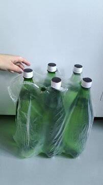 Woman picking bottle from pack of drinking water, bottled water storage, clean water supply and emergency preparedness.