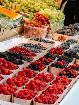 Colorful display of fresh raspberries, blueberries, blackberries, grapes and currants at the vibrant Central Market in Ljubljana, Slovenia.