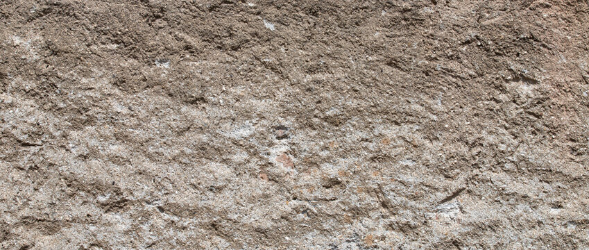 Rough brown concrete wall surface texture background with uneven porous plaster