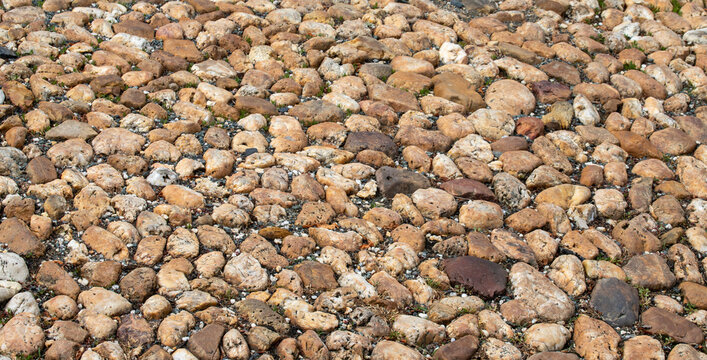 Natural cobblestone ground pavement texture background with rounded river rocks