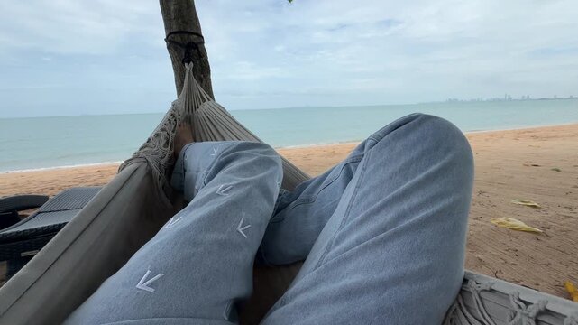 First-Person View of Relaxing in a Hammock by the Beach. Calm summer vacation mood in tropics.