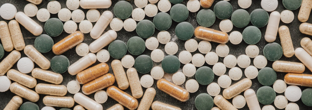 Top view flat lay background of various green chlorella pills and herbal capsules for healthy lifestyle organic dietary supplement and nutrition overview concept