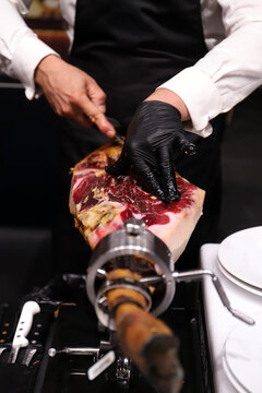 experto del corte de jam&oacute;n cortando jam&oacute;n ib&eacute;rico con sus manos y cuchillo jamonero
