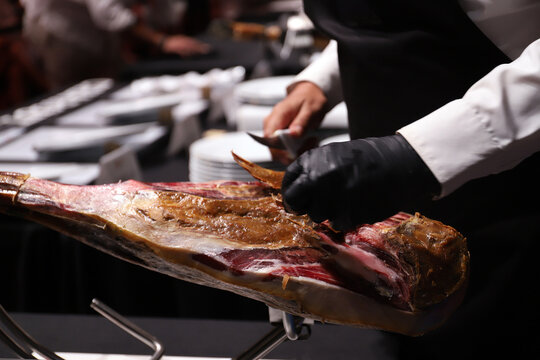 experto cortador de jam&oacute;n ib&eacute;rico limpiado de tocino y capa un jam&oacute;n