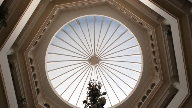 Looking up at the skylight glass roof of an atrium, with geometric structure in modern contemporary architectural style