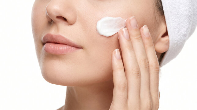 Woman using white moisturizer on clear skin, symbolizing freshness, hydration, confidence, and cosmetic care.