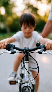 Young boy with Down syndrome riding a bicycle, gripping handlebars tightly, with a blurred background of greenery and soft sunlight illuminating the scene