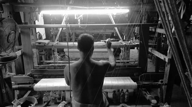 4k 120 fps slow motion video of a handloom weaver in India working in his loom.	
