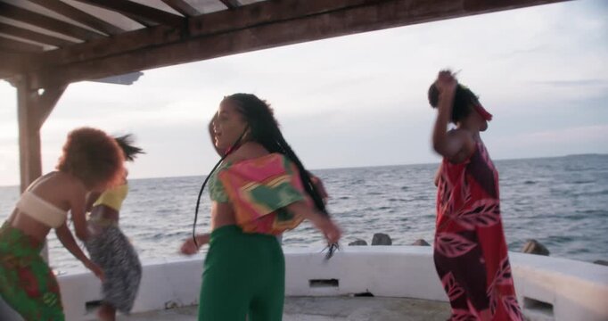 Five beautiful girls dancing salsa attractively on a pier, Colombia